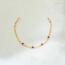 Gold plated bracelet with multiple sapphire blue evil eye charms